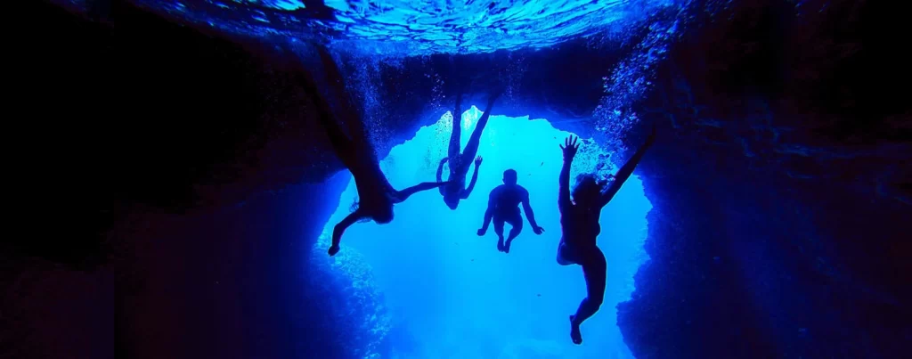 People diving in Blue Cave, Biševo Island, Croatia